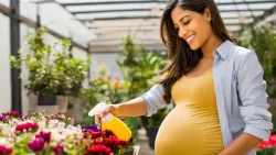 a pregnant woman spraying flowers